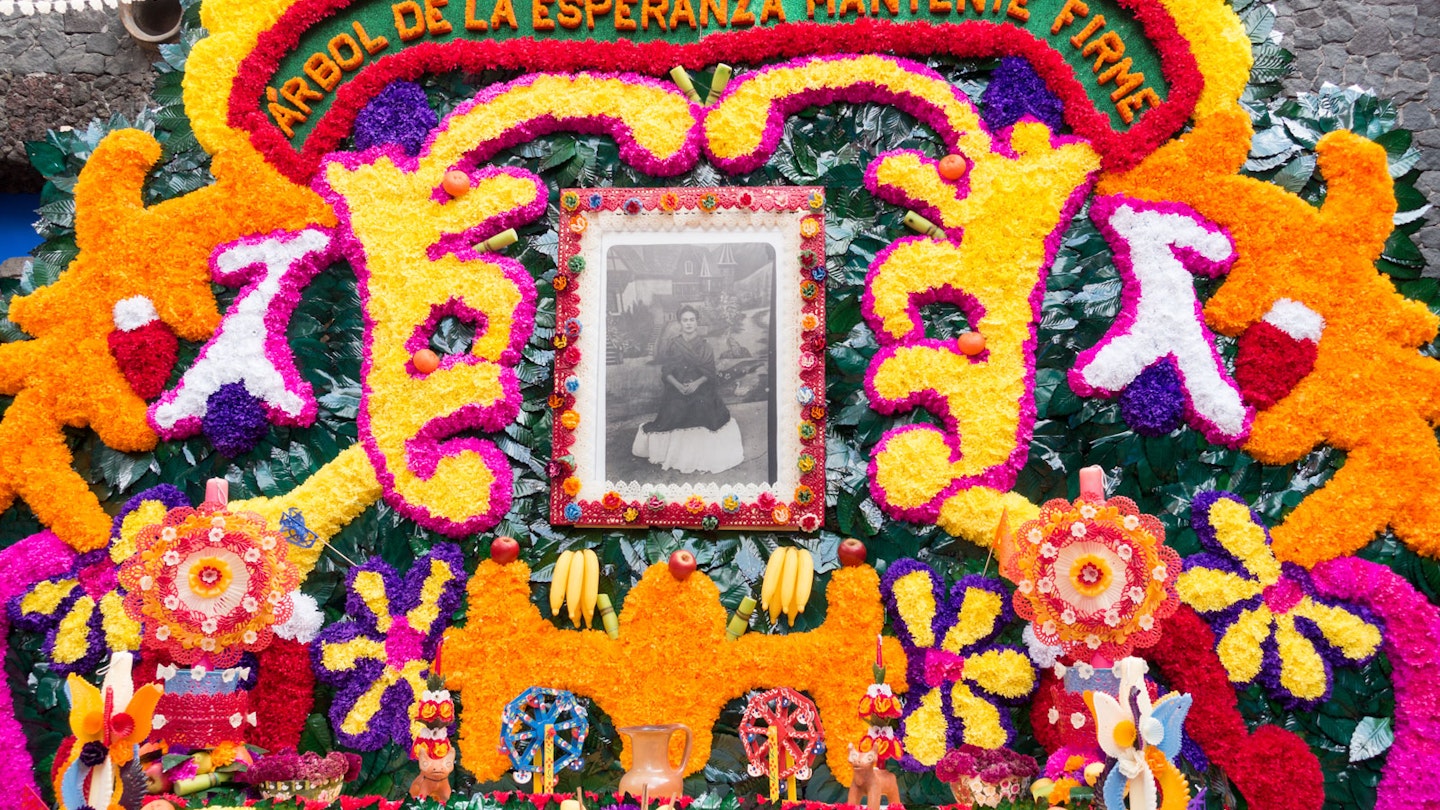 A wide array of vibrantly colored flowers form a frame around photograph of Frida Kahlo © Seastock / Getty Images