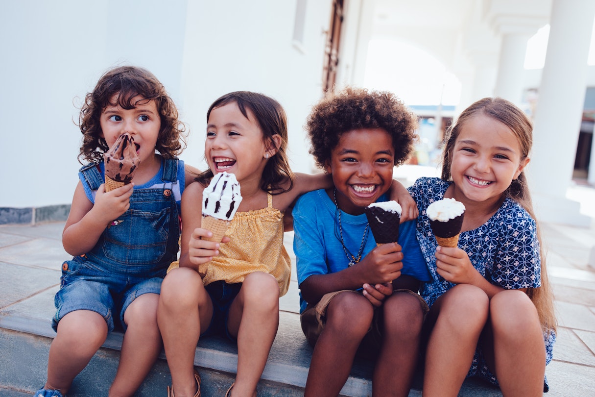 Four kids enjoy ice cream together smiling © Wundervisuals / Getty Images