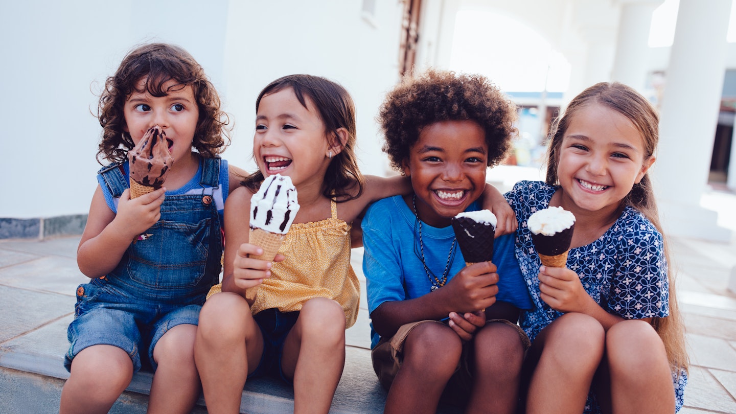 Four kids enjoy ice cream together smiling © Wundervisuals / Getty Images