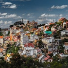 Looking across a gully to the Rova at a hilltop, with colourful buildings jumbled together on the slopes below © G & M Therin Weise / robertharding / Getty Images
