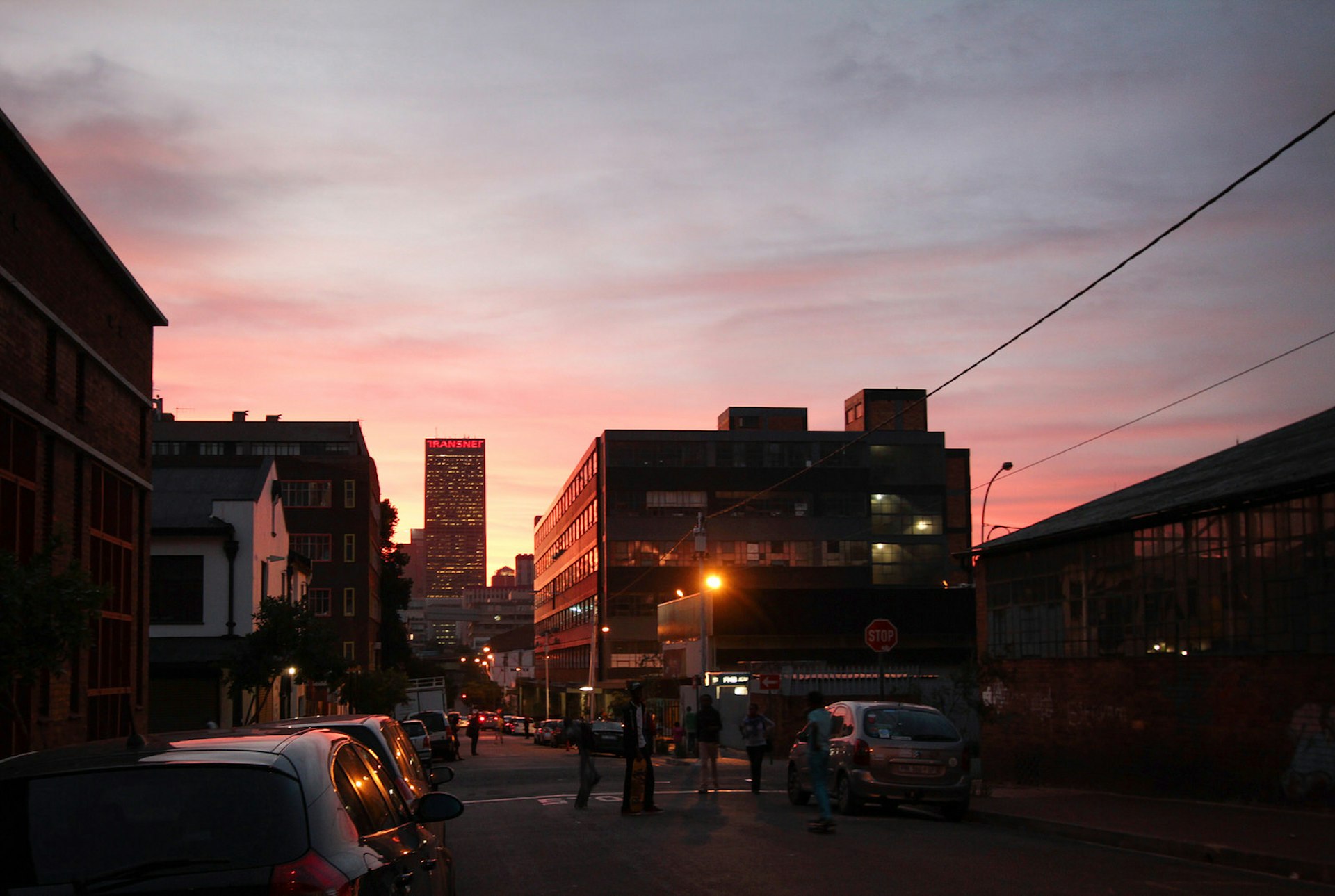 A shot of an intersection, with a bright pink-and-orange sky backing the surrounding buildings and traffic. Maboneng is one of Johannesburg's best neighourhoods © Heather Mason / Lonely Planet