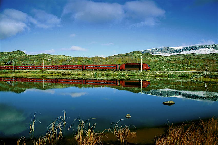 Features - Bergensbanen train mirrored in Lake Ustevatn near Hallingskarvet mountains. The Begensbanen traverses Norway's countryside © Pete Seaward / Lonely Planet