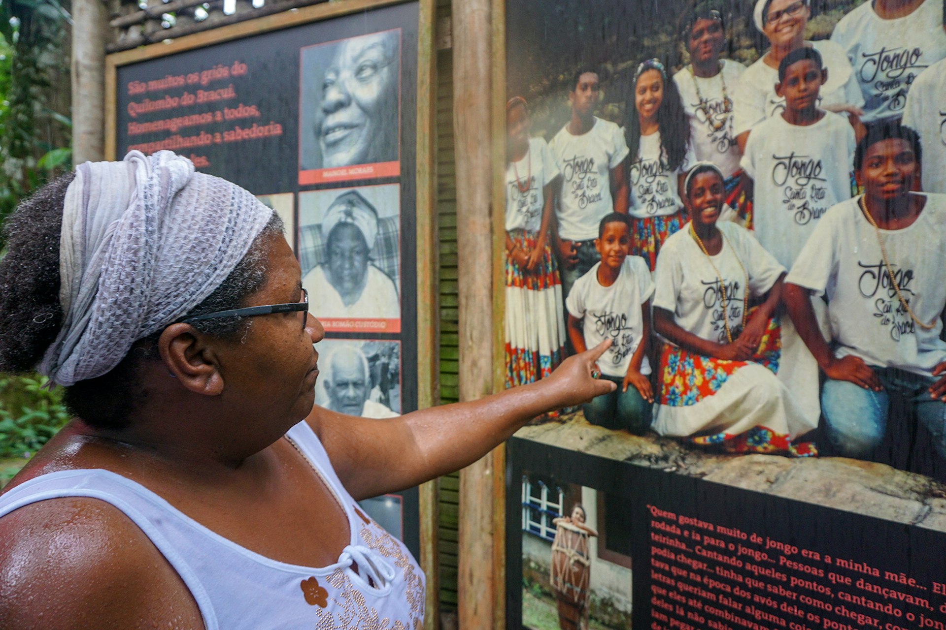 A woman points to a picture of several young adults on an informational board © Kiratiana Freelon / Lonely Planet