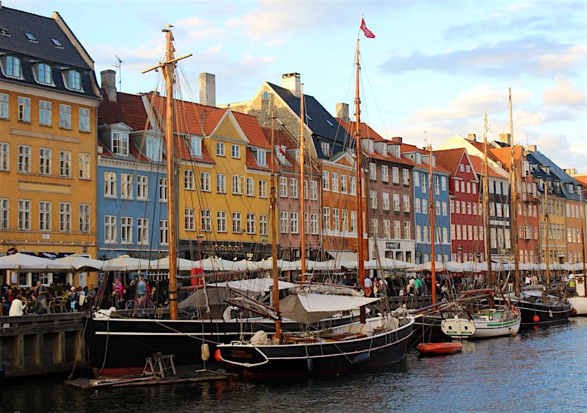 The colourful buildings at Copenhagen's Nyhavn, with boats moored along the harbour's edge © Caroline Hadamitzky / Lonely Planet