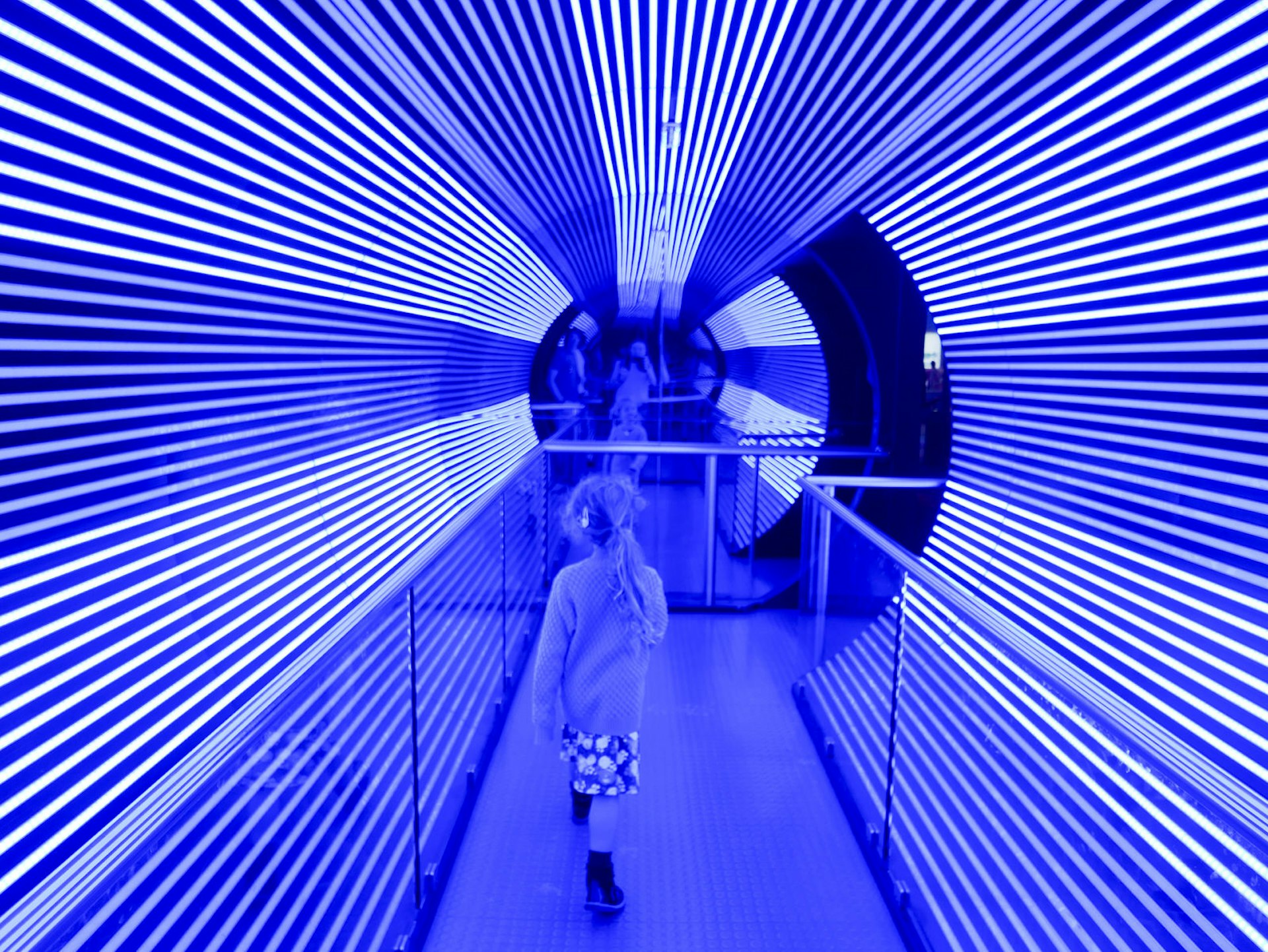 A girl walks through a purple neon tube at Questacon science museum © Christine Knight