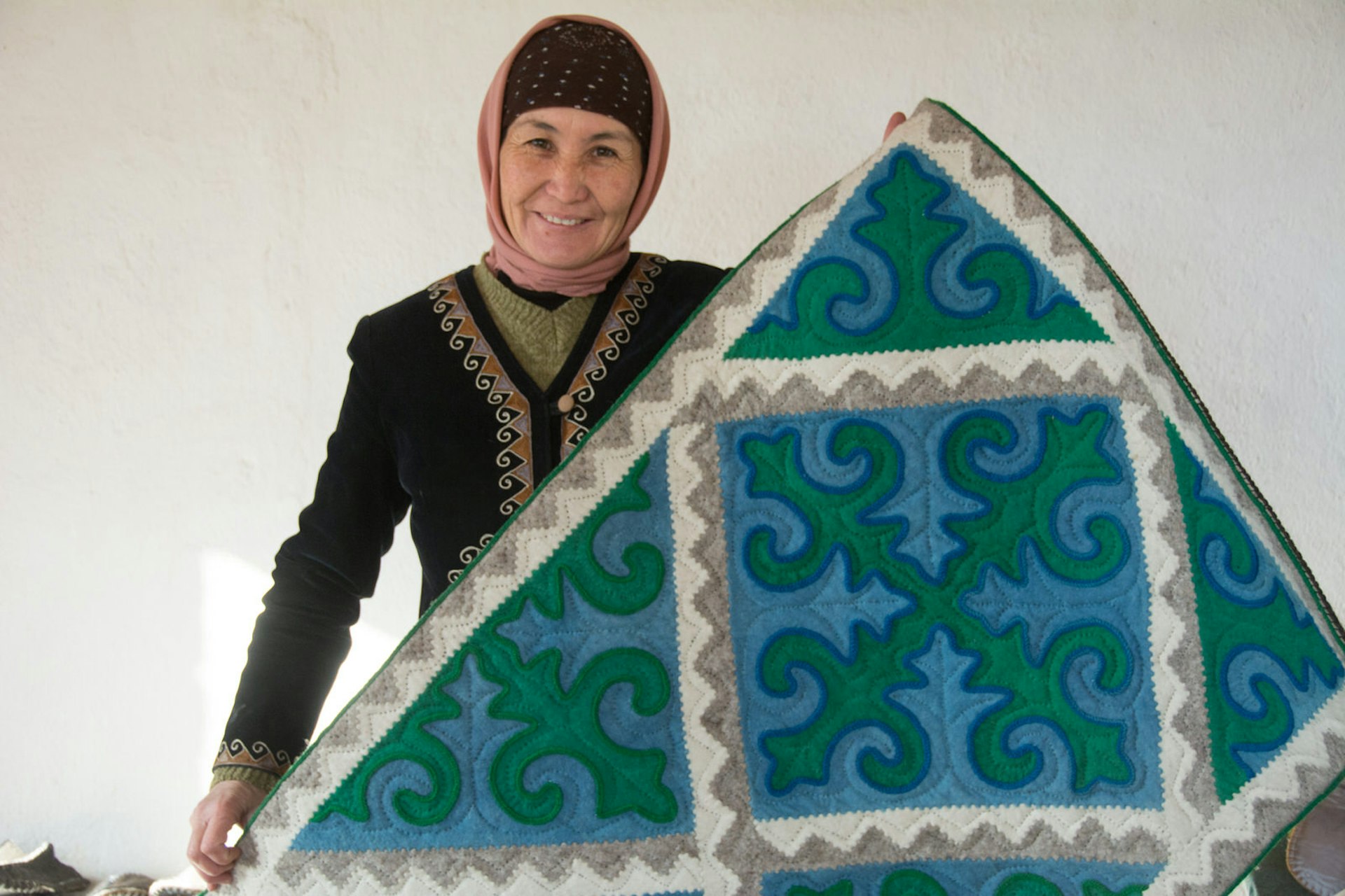 Janyl shows off the shyrdak (traditional Kyrgyz felt carpet) we bought for an 80th birthday present © Uncornered Market