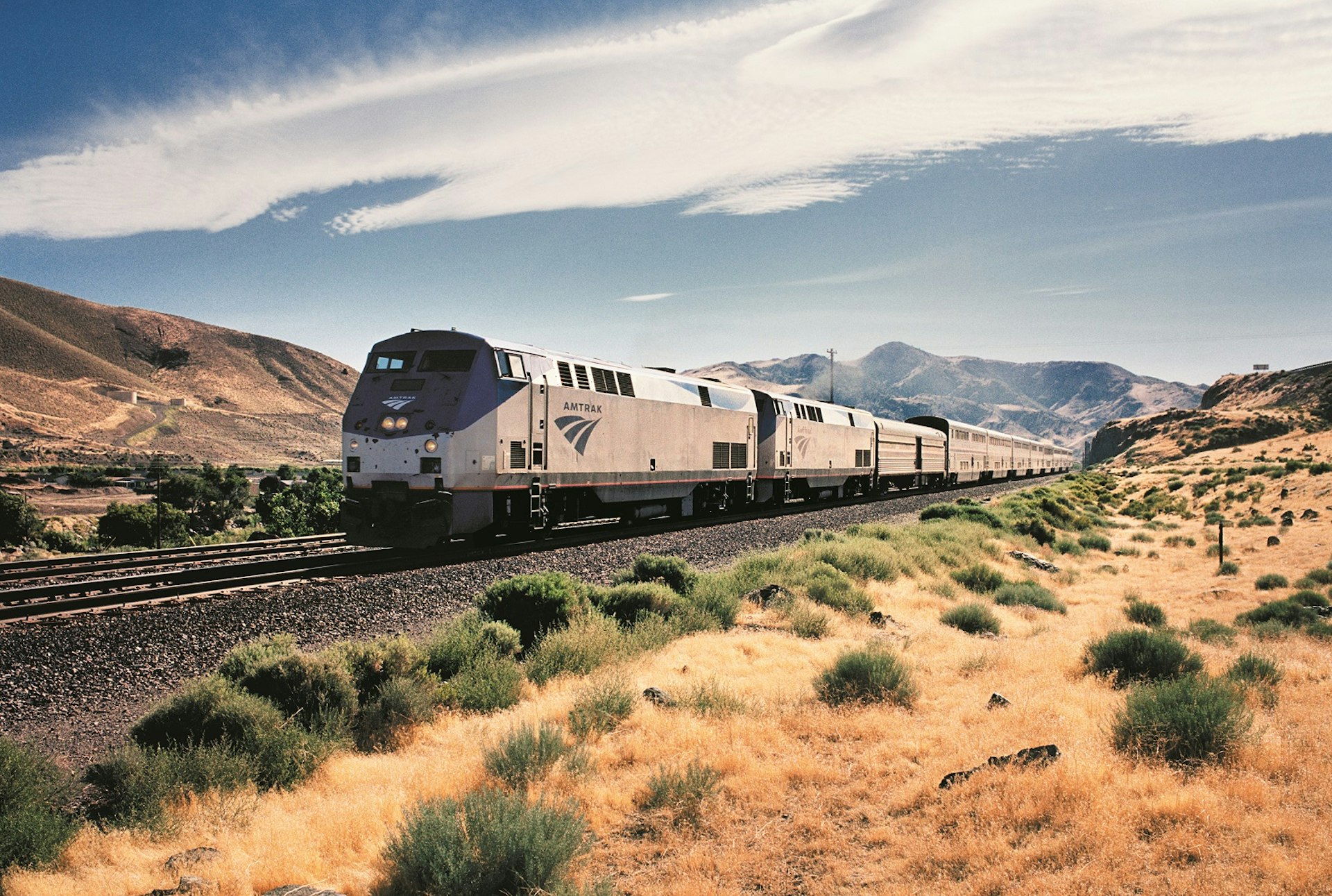 An Amtrak train passing on tracks through the US countryside