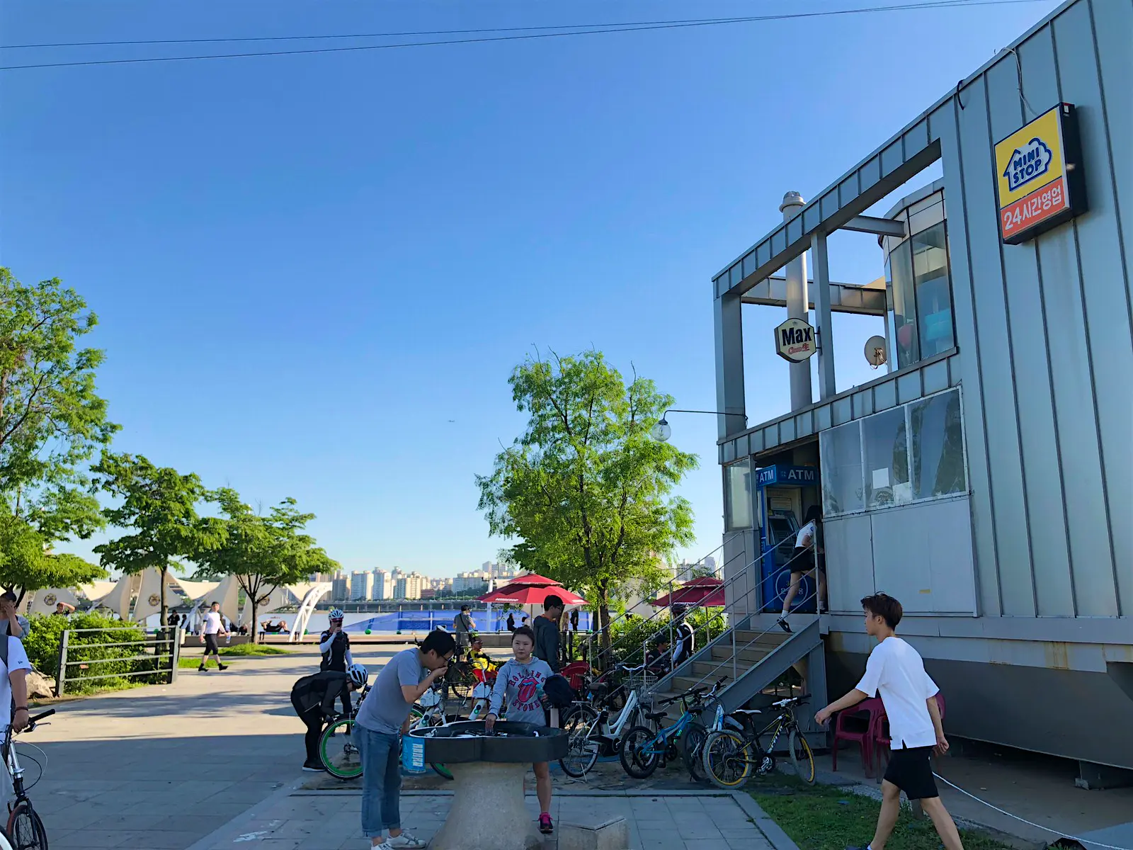 Features - This GS25 store has views of the Han River and Banpo Bridge light show © Hahna Yoon / Lonely Planet A sunny day with bike parking and some people enjoying the park. This convenience store has views of the Han River © Hahna Yoon / Lonely Planet