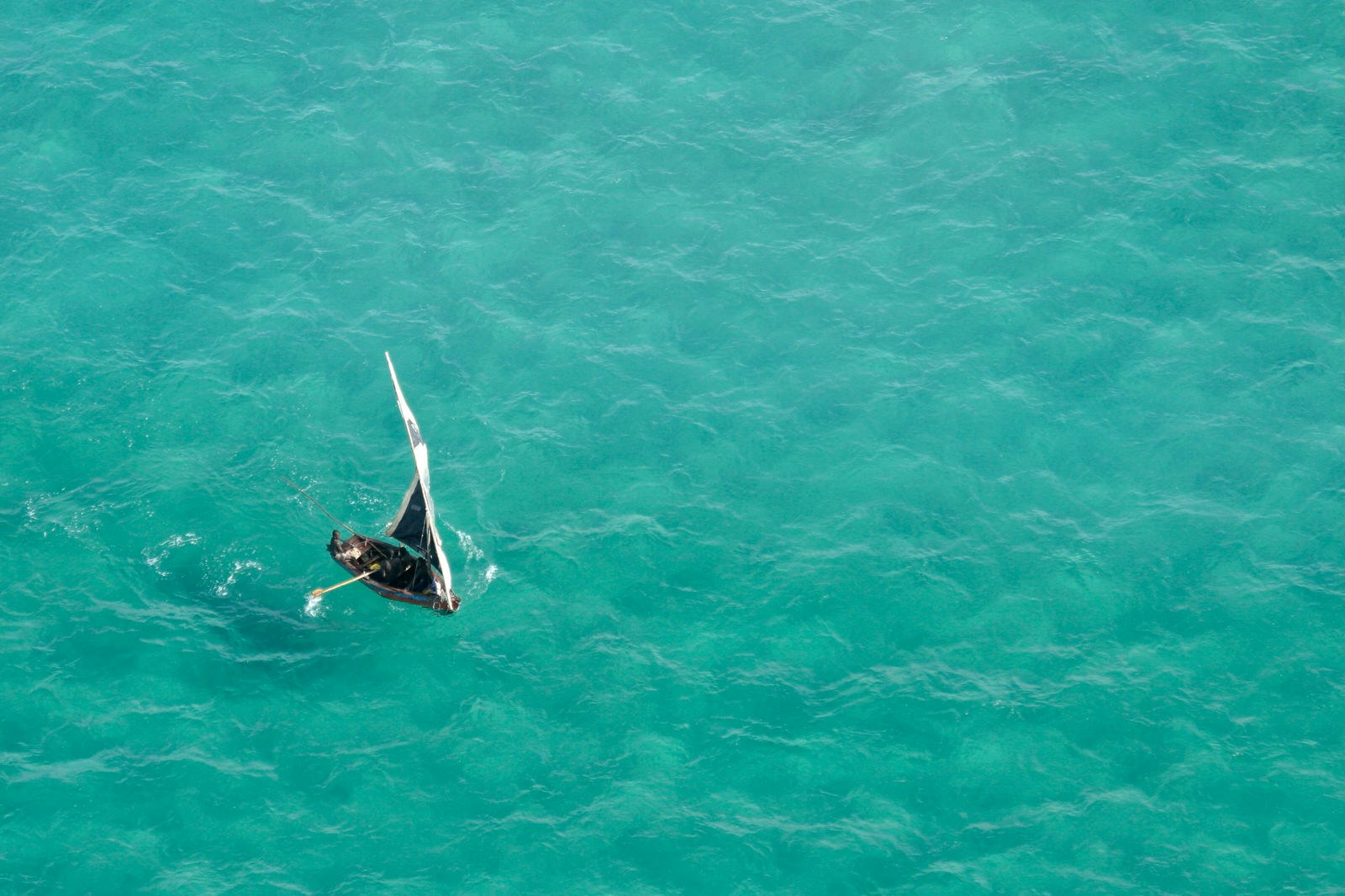Aerial view of a small sailboat (called a dhow) on the open sea, Mozambique, southern Africa © EcoPic / Getty Images