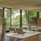 Wide interior shot of Glass House with mid-century modern furnishings on a white rug © Michael Biondo