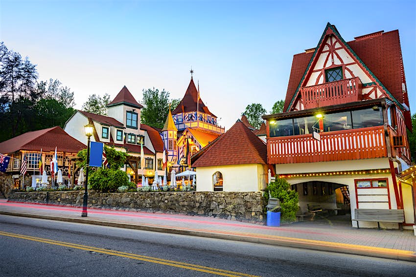 Several Bavarian-style timbered buildings line the main street in Helen, Georgia, under blue skies © Sean Pavone Photo / Getty Images