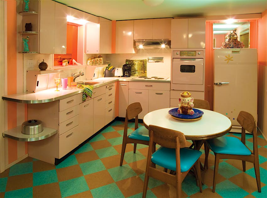 Wide interior shot of a mid-century modern turquoise, pink and orange kitchen, with colored linoleum flooring and pale pink cabinetry Â© Lazy Meadow LLC