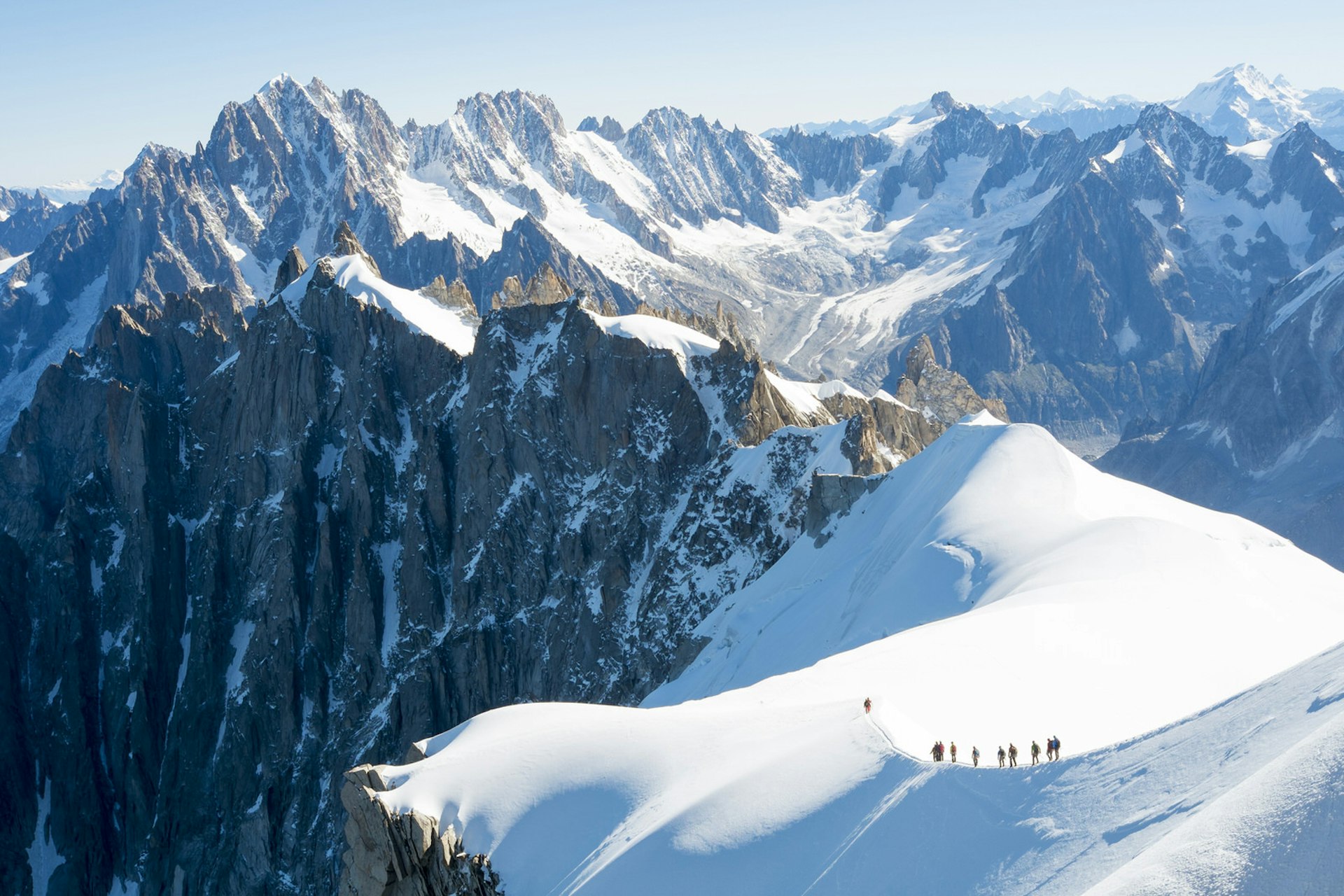 Mont Blanc mountaineers walking on snowy ridge © Nando Machado / Shutterstock