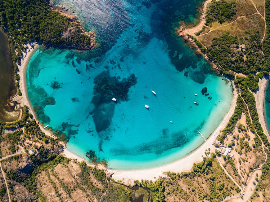 Aerial view of Rondinara beach in Corsica, a stunning turquoise pool circled by pristine white sand