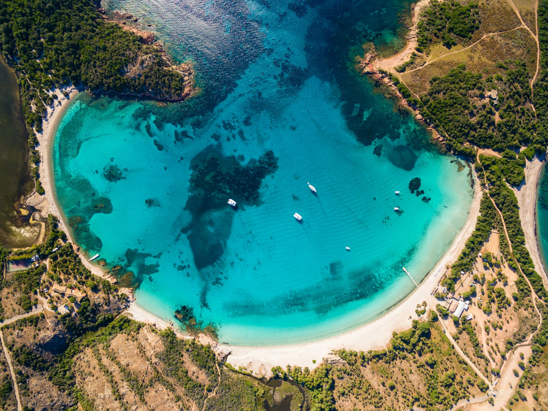 Flygfoto över Rondinara-stranden på Korsika, en fantastisk turkos pool omgiven av orörd vit sand