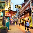 Early evening lights on along a busy food street. Rua do Cunha: Macau's unofficial food street © Tang Yan Song / Shutterstock