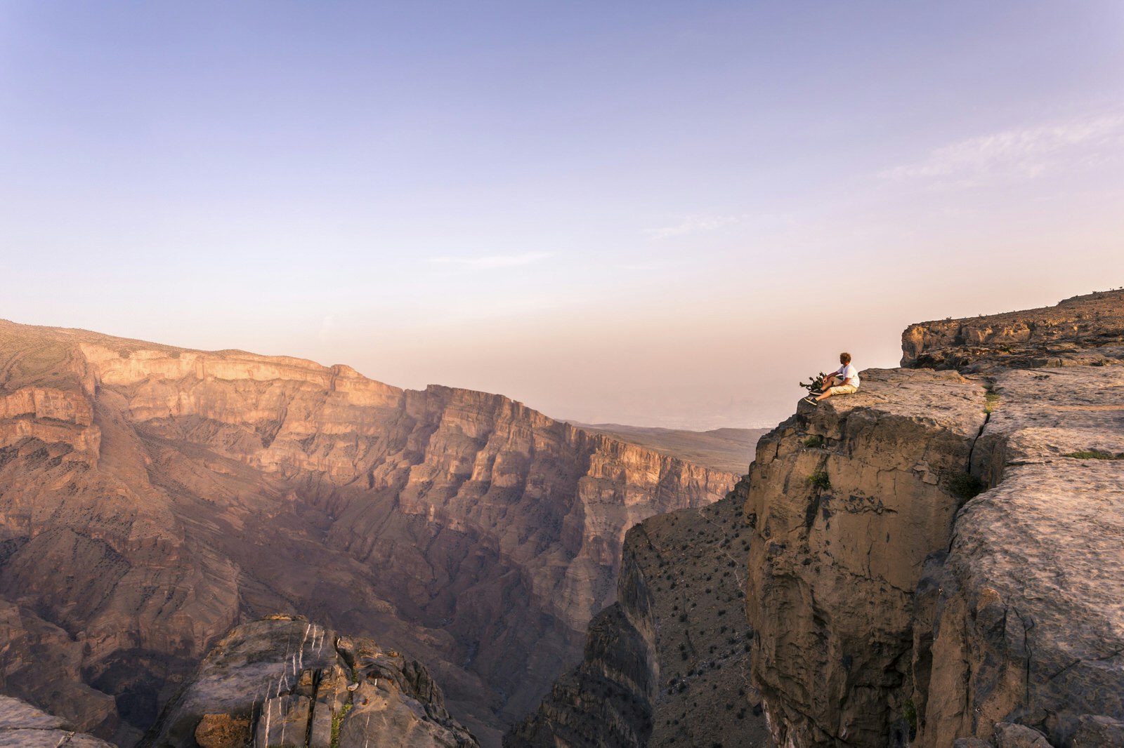 Oman, Wadi Ghul, Jebel Shams. The Grand canyon of Oman, tourist on the edge looking at view, at sunset ©  Matteo Colombo / Getty Images