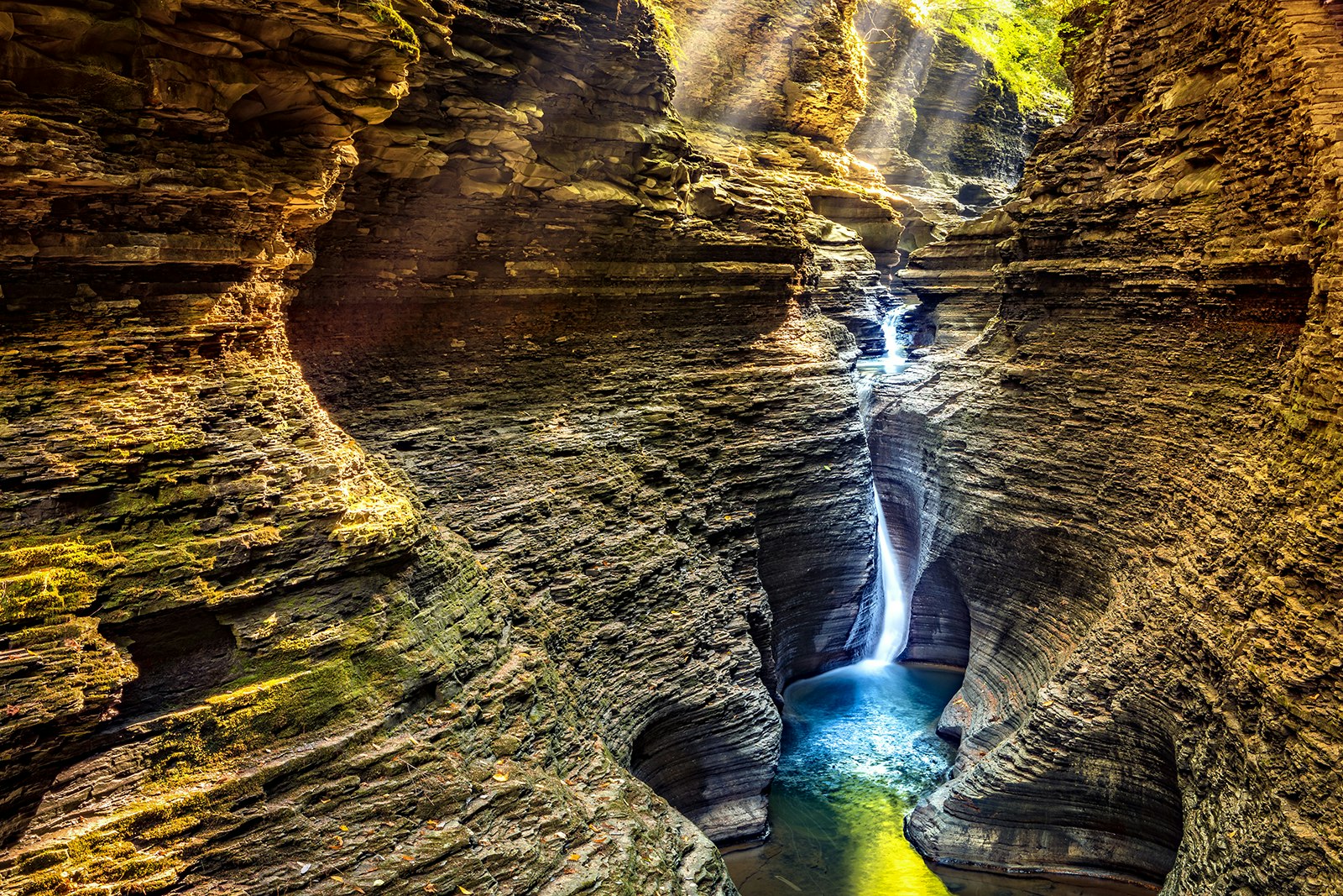 A waterfall in a canyon in Watkins Glen is illuminated by light from above © Ultima_Gaina / Getty Images