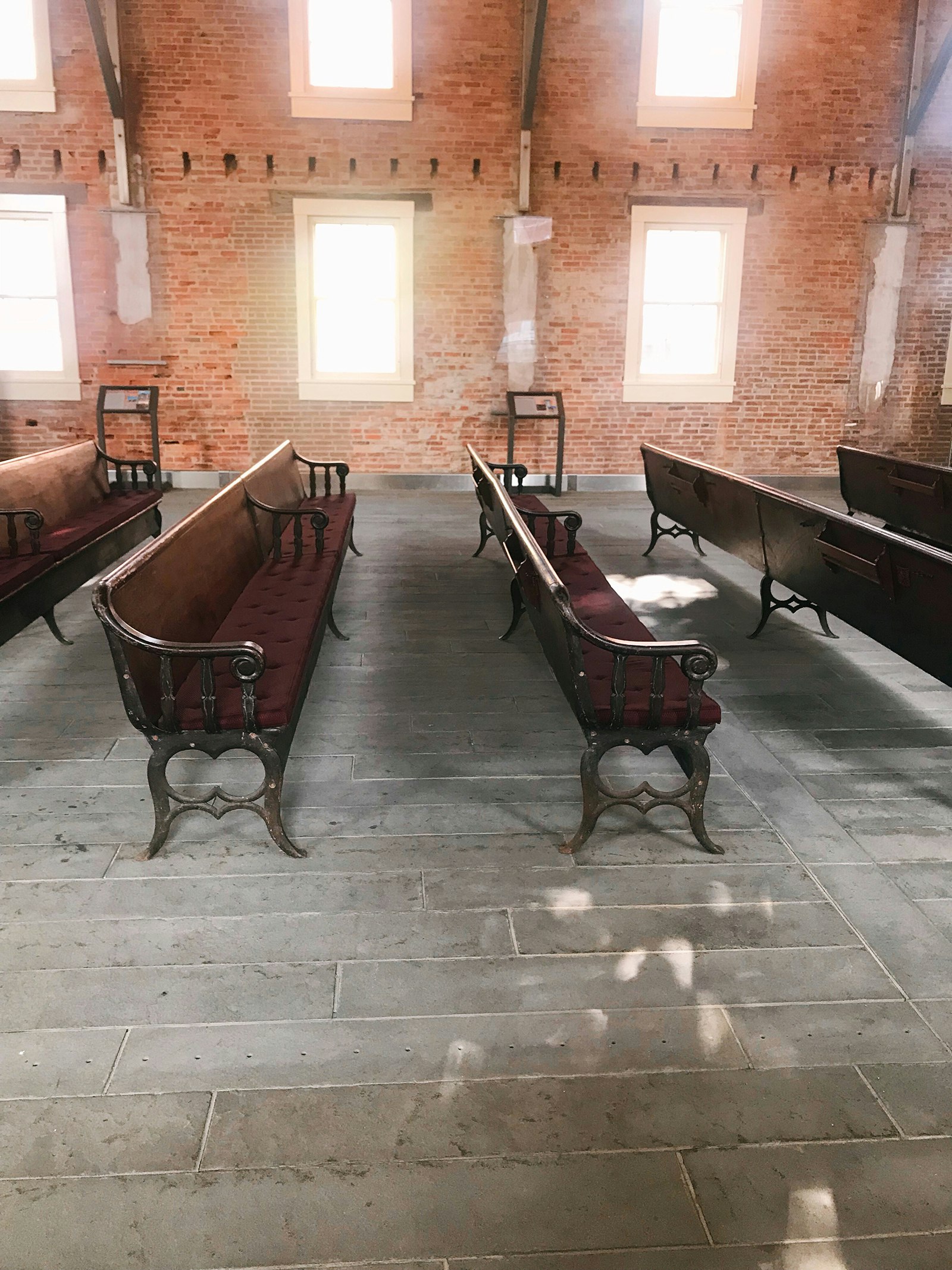 Interior of small brick chapel full of natural light and ornate original wooden pews© Mikki Brammer / Lonely Planet 