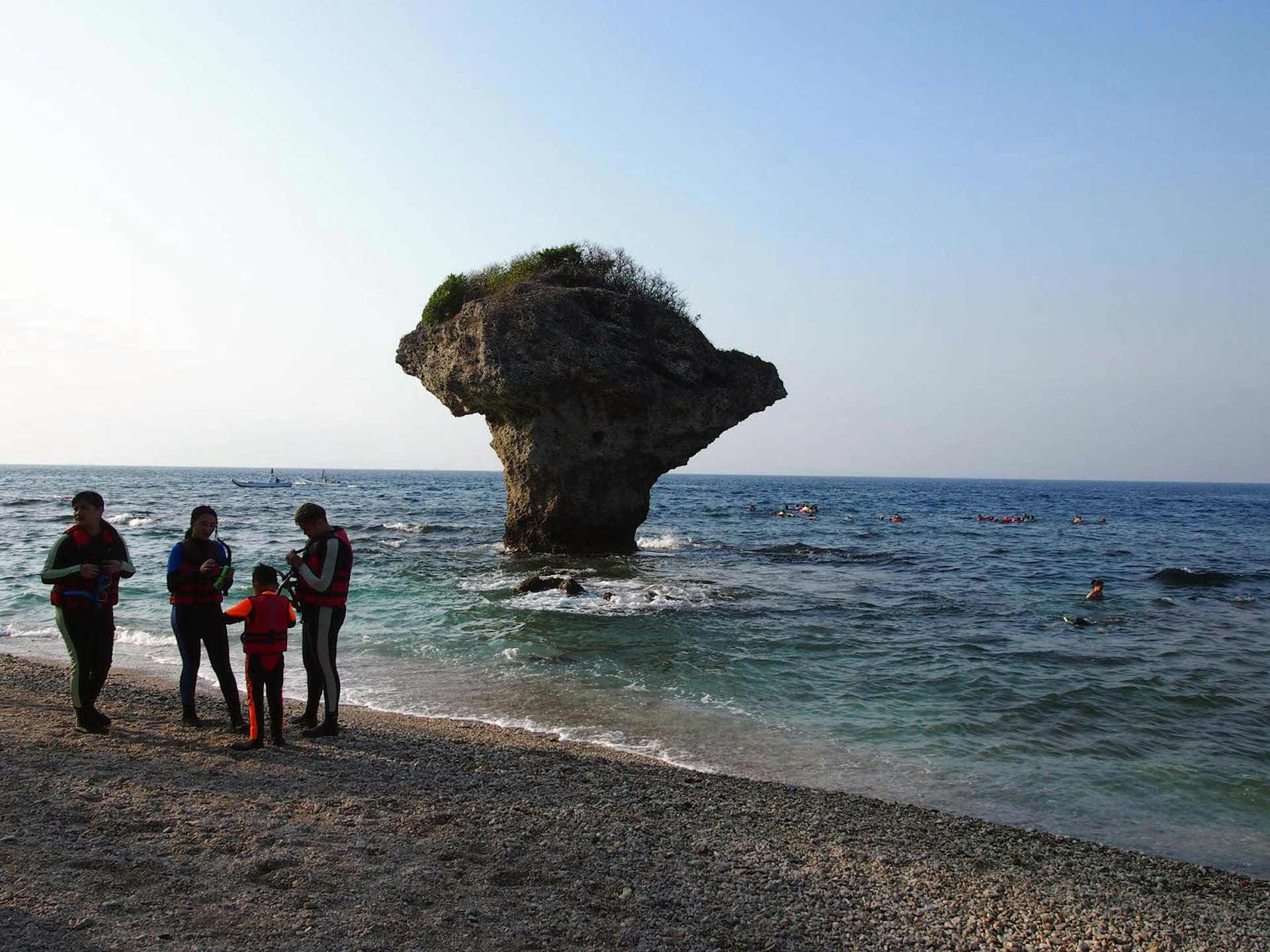 A family prepares to go snorkelling on the beach in front of Vase Rock. The waters around Vase Rock are the most popular place for snorkelling © Tess Humphrys / Lonely Planet