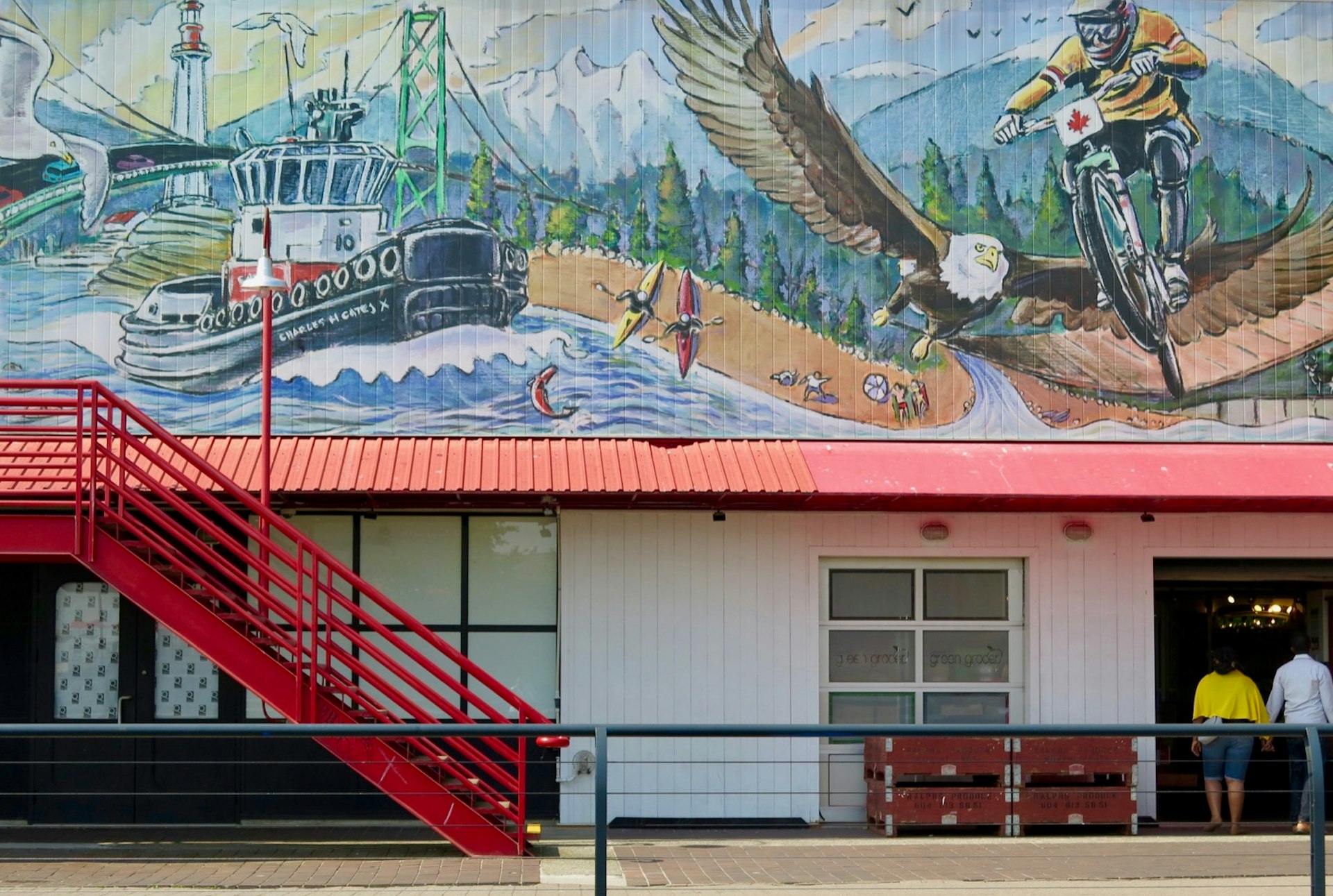 A mural featuring a soaring eagle and a fishing boat pulling up to a sandy shoreline covers one wall of a public market © John Lee / Lonely Planet