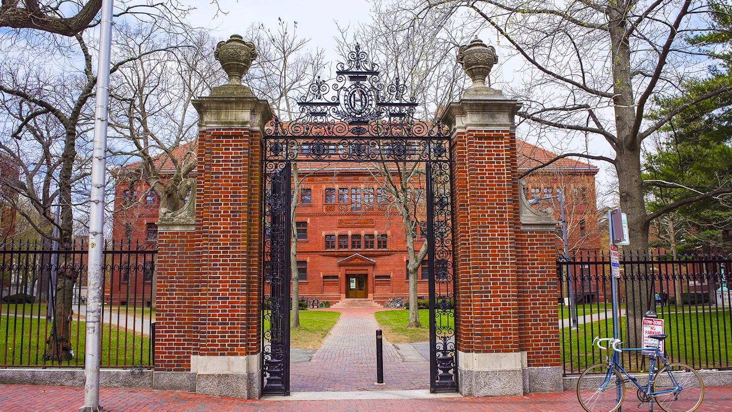 red brick gateposts and wrought iron, open gate leading to a redbrick residence hall at Harvard on a sunny day