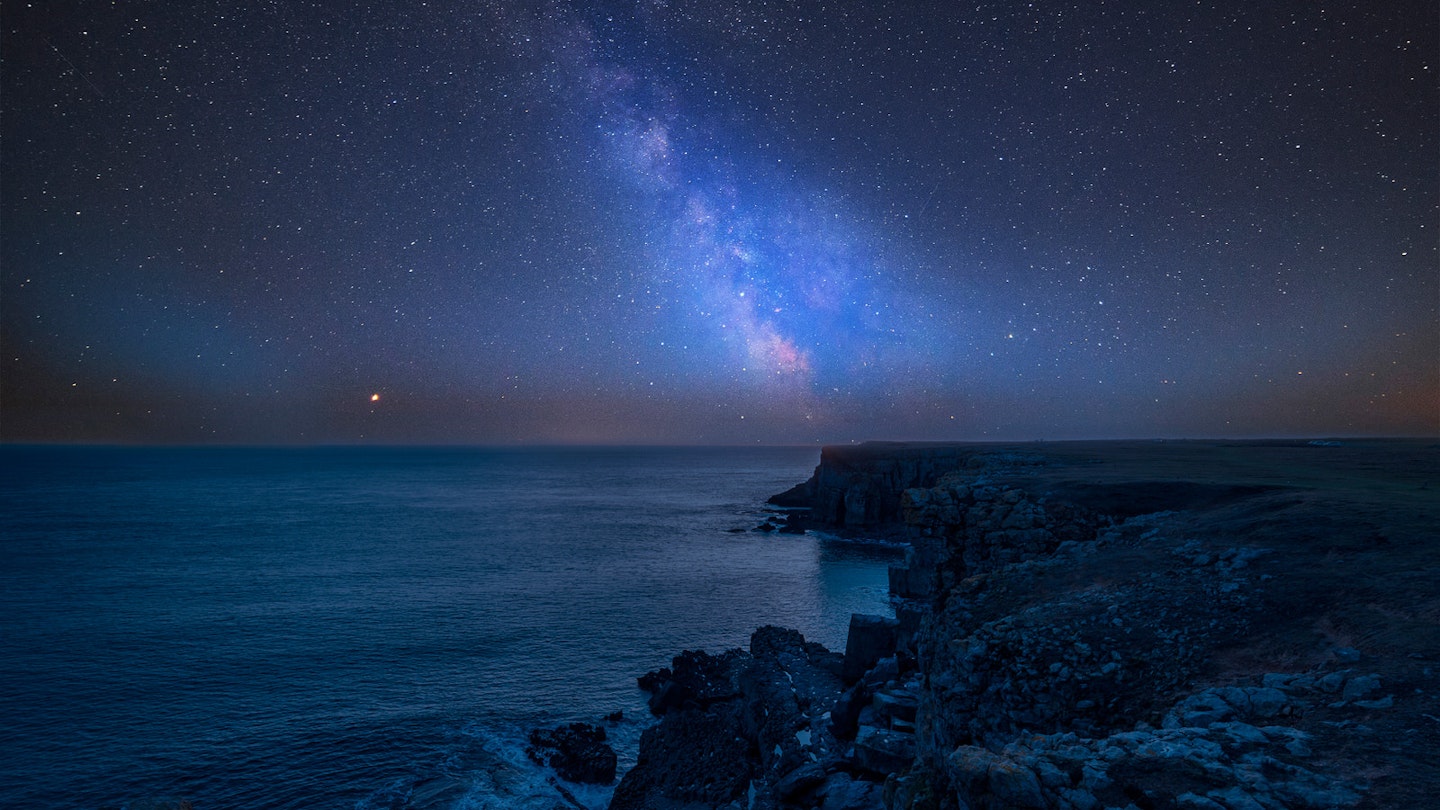 The Milky Way streaking above St Govan's Head on Pembrokeshire Coast in Wales © Matt Gibson / Shutterstock