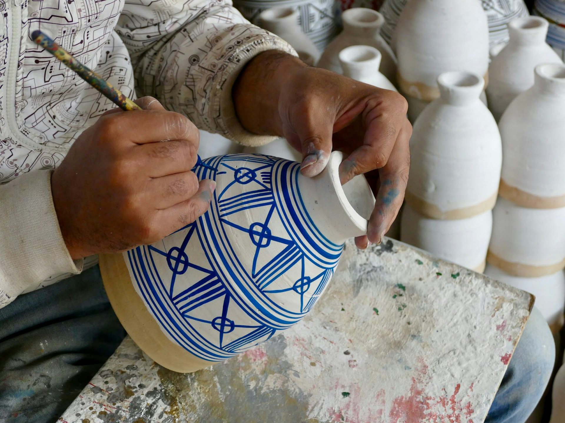 Craftsman painting a drum base in Fez, Morocco