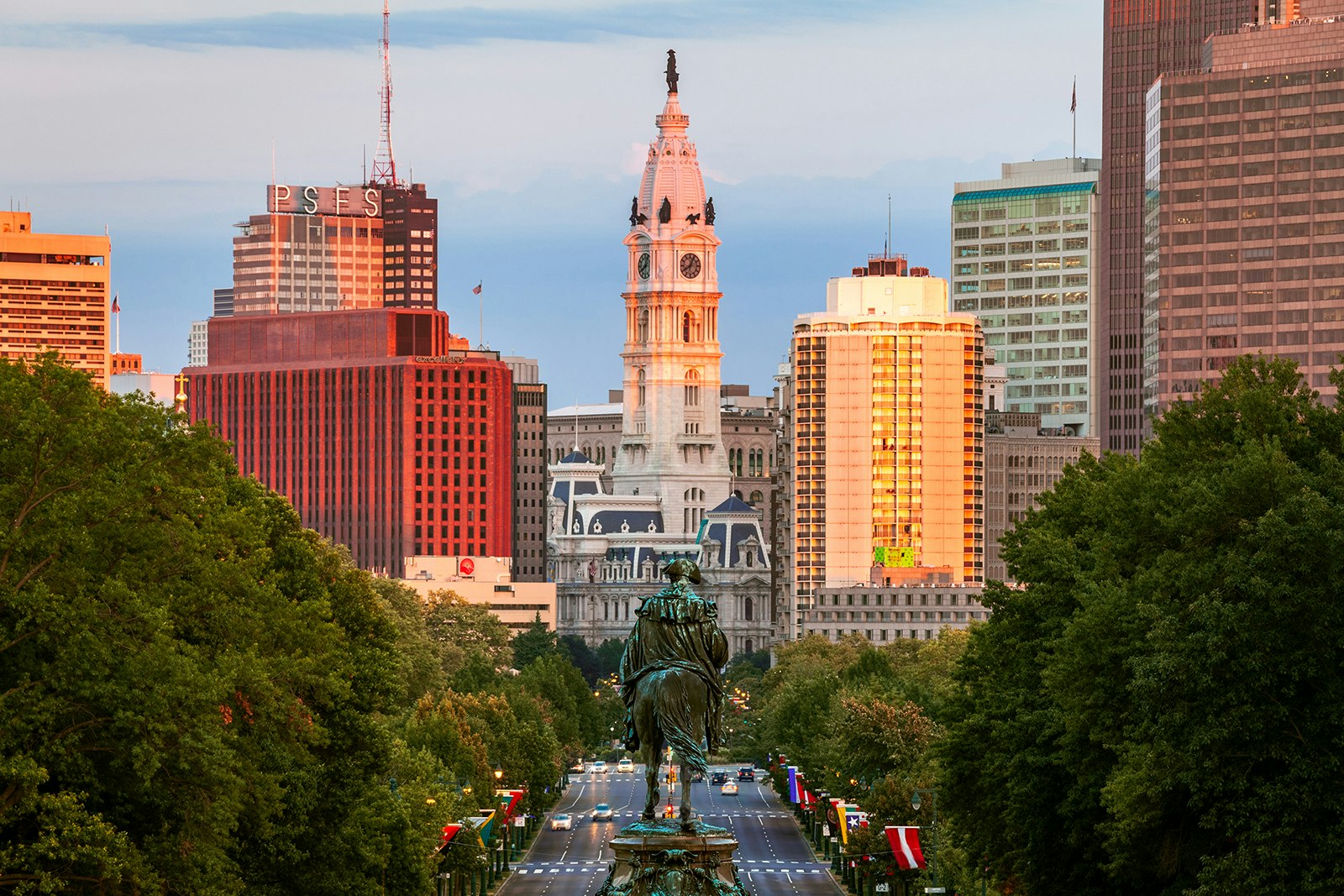 View of Philadelphia's gothic City Hall at sunset, with high rise buildings on either side