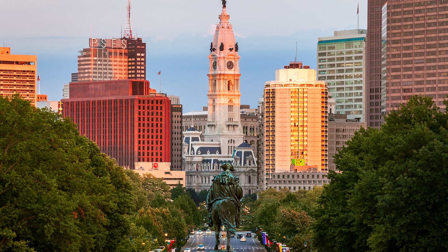 View of Philadelphia's gothic City Hall at sunset, with high rise buildings on either side