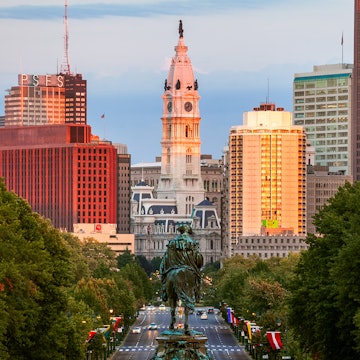 View of Philadelphia's gothic City Hall at sunset, with high rise buildings on either side