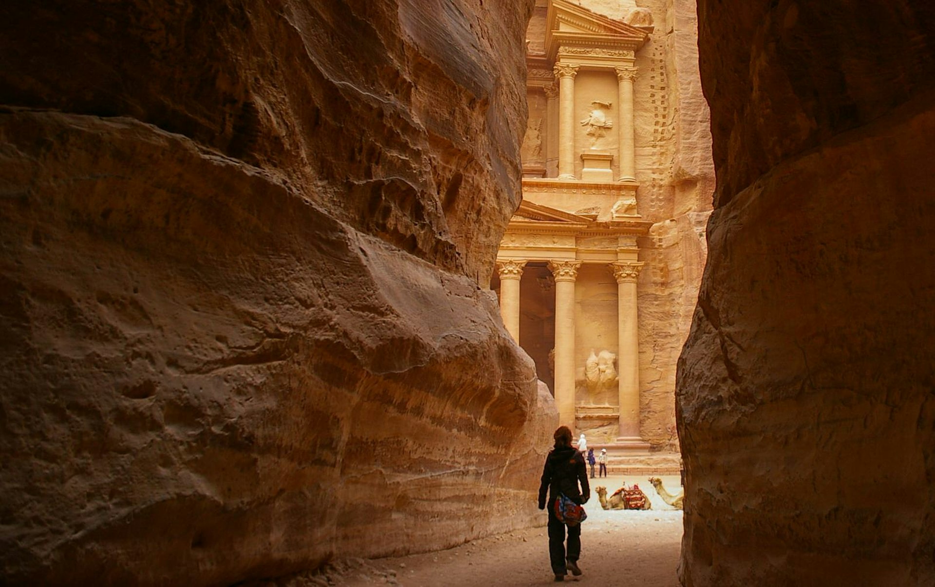 A view of The Treasury temple at Petra, Jordan, framed by a rocky passageway