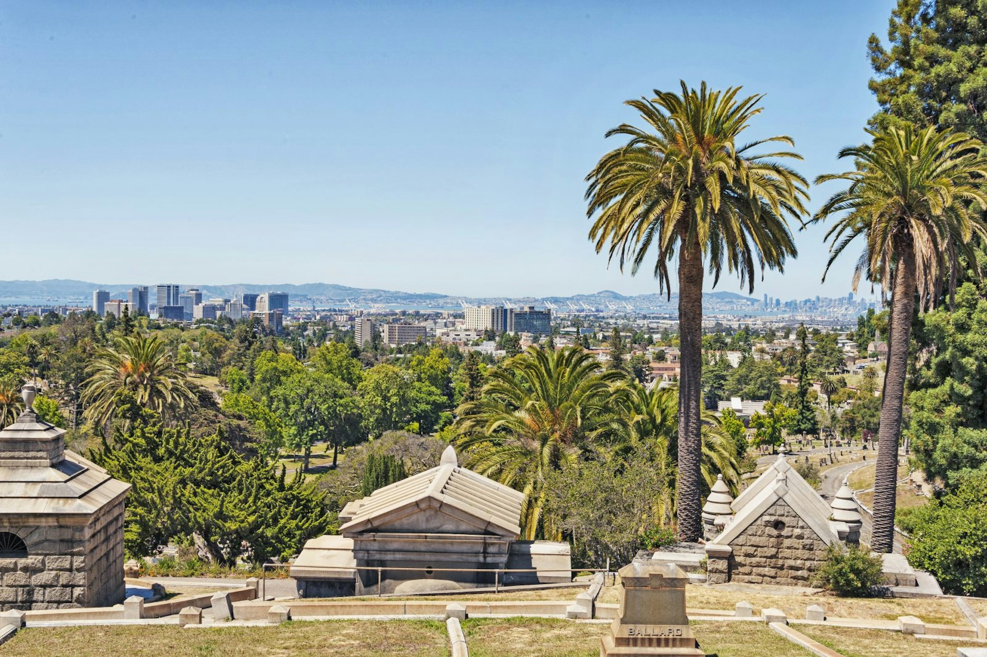 The skylines of Oakland and San Francisco appear on the horizon from a high point in Mountain View Cemetery