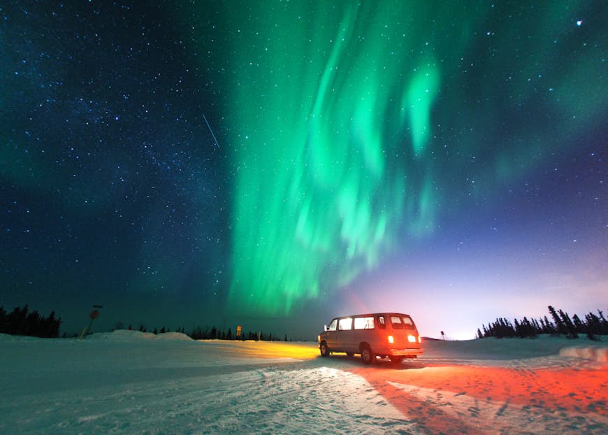 The Northern Lights in the sky above a van parked near Fairbanks, Alaska
