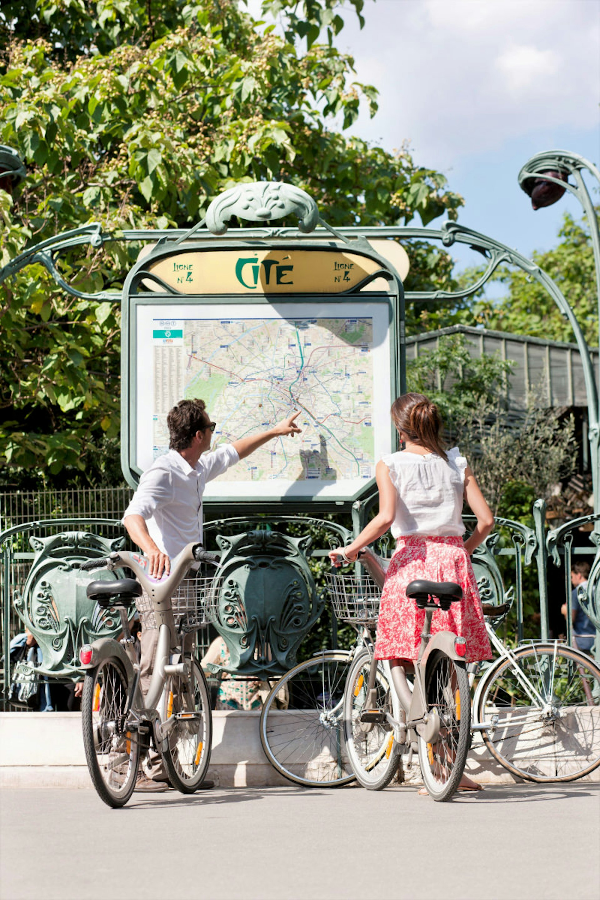 A couple of Vélib’ bicycles look at a map in Paris