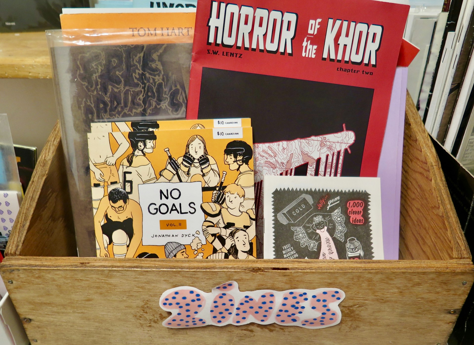 A box of zines at Lucky's Books & Comics in Vancouver. Titles include No Goals Vol II, Horror of the Khor and 1000 clever ideas; Vancouver's best bookstores.