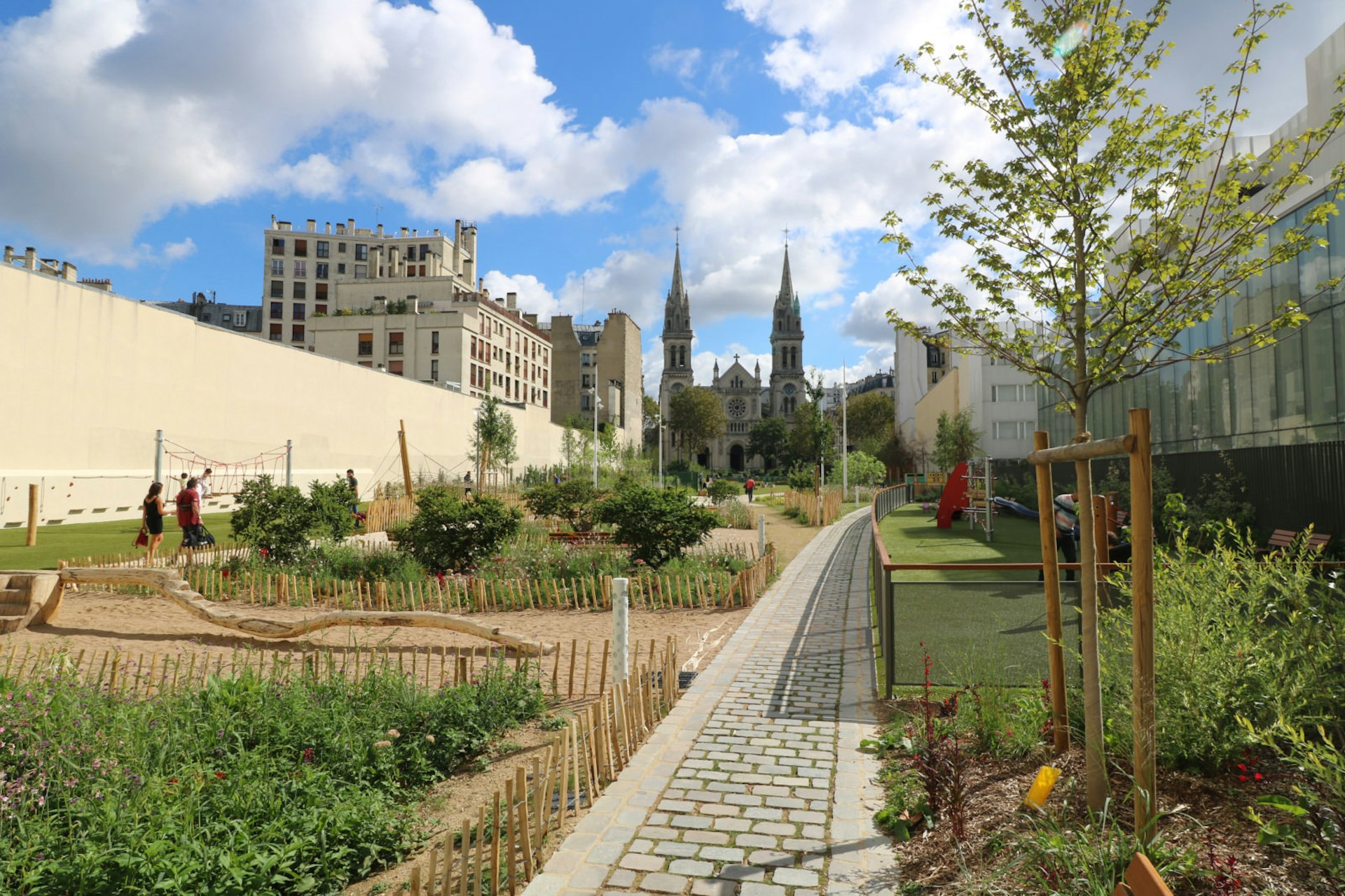Église St-Ambroise is seen through the greenery of the newly-opened Jardin Truillot in Paris