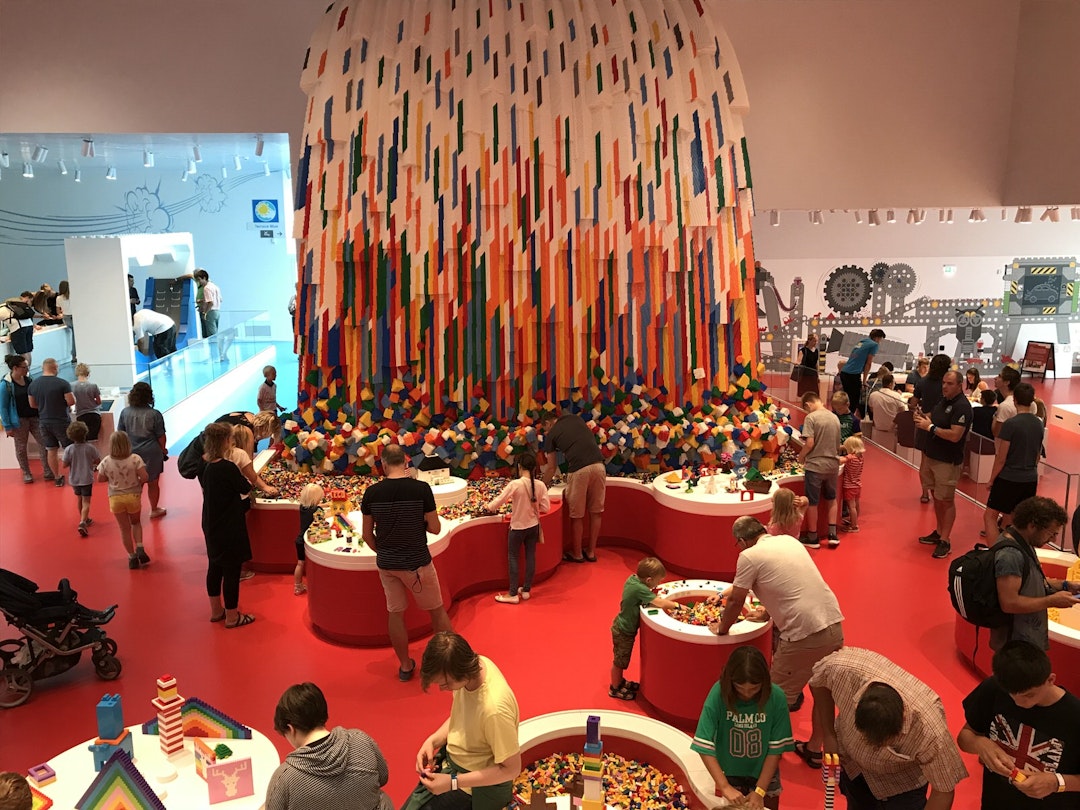 Adults and children playing with brightly-coloured Lego bricks inside the Lego House in Billund © Abigail Blasi / Lonely Planet