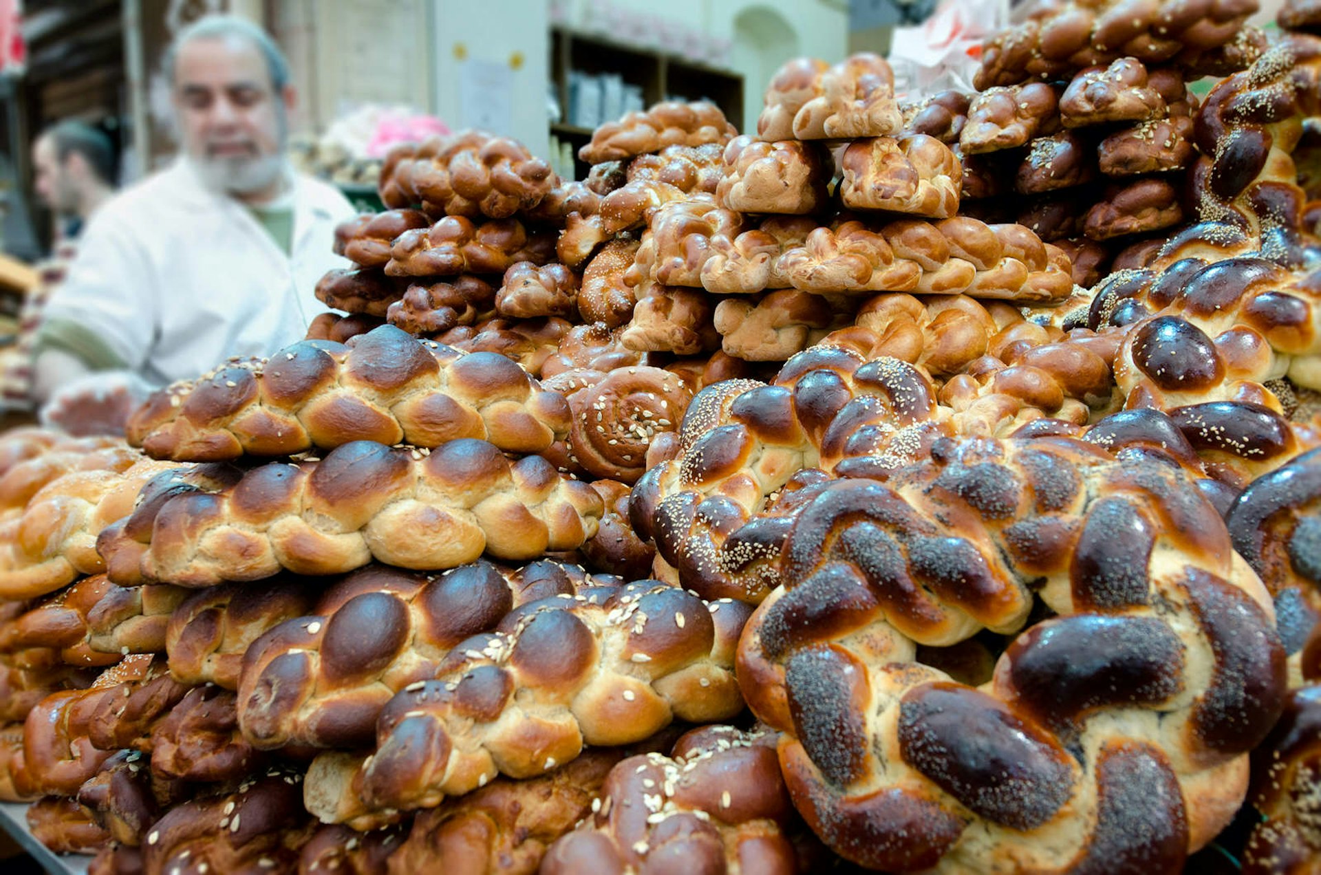 Jewish man buys challah bread for Shabbat at Mahane Yehuda Market, Jerusalem