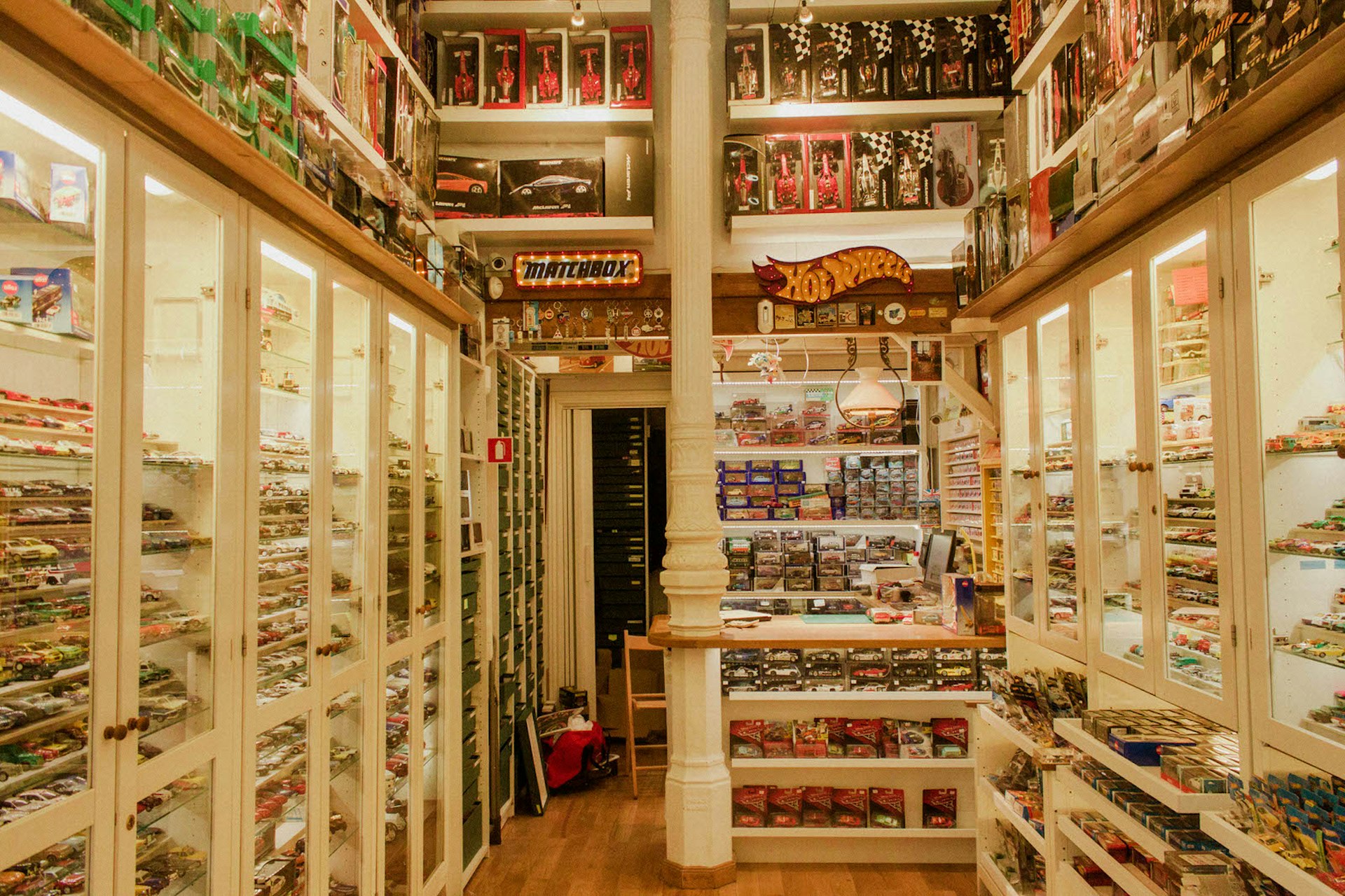 macchinine's thousands of toy cars, arranged by brand, line the white glass-front shelves in a high-ceilinged shop in Madrid