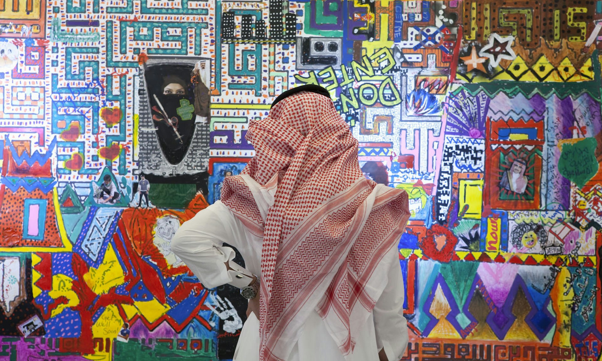 Saudi man looks at art at a children's art show at the Kingdom Tower in Riyadh, Saudi Arabia