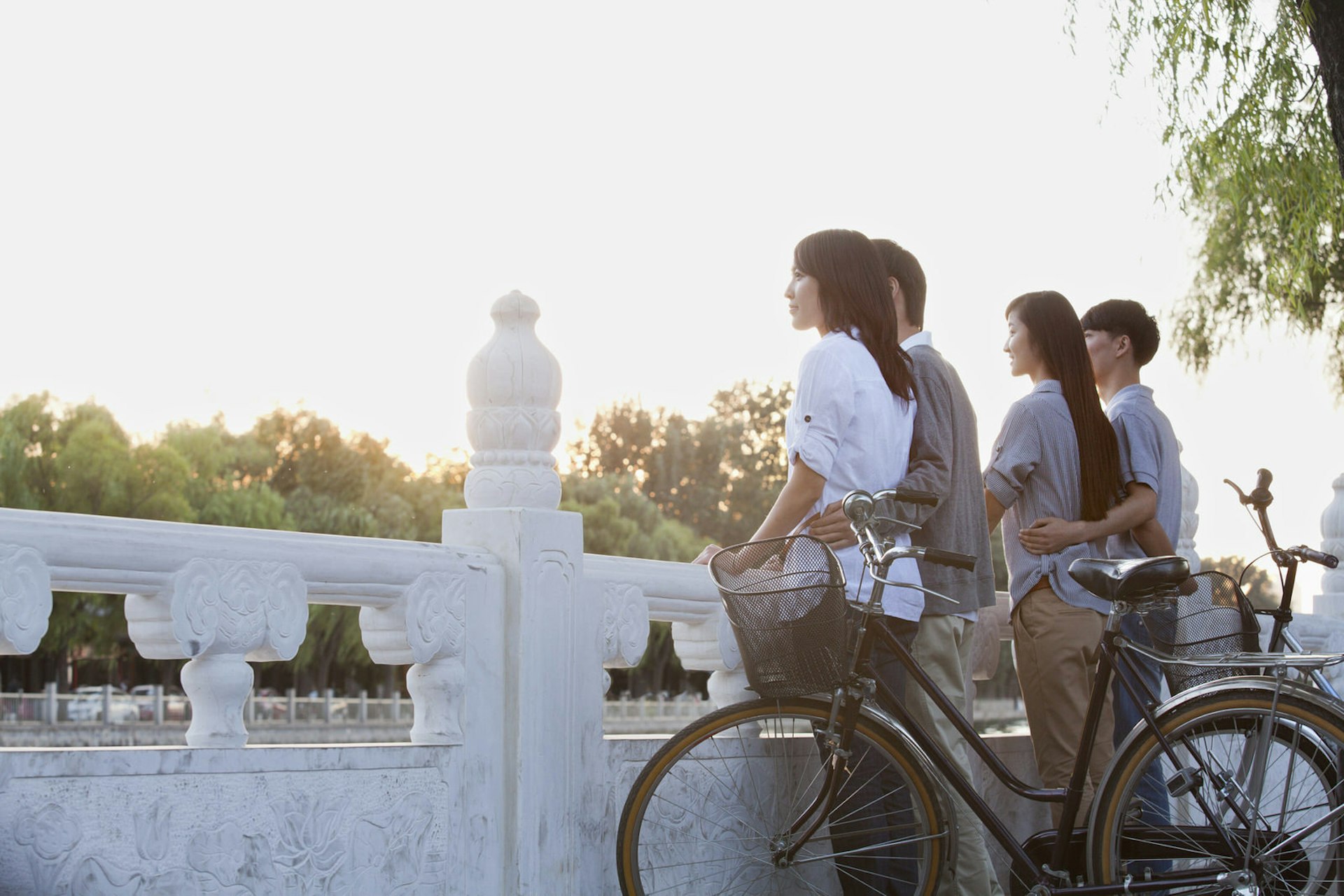 Two couples with bikes admire the view of Houhai Lake, Beijing