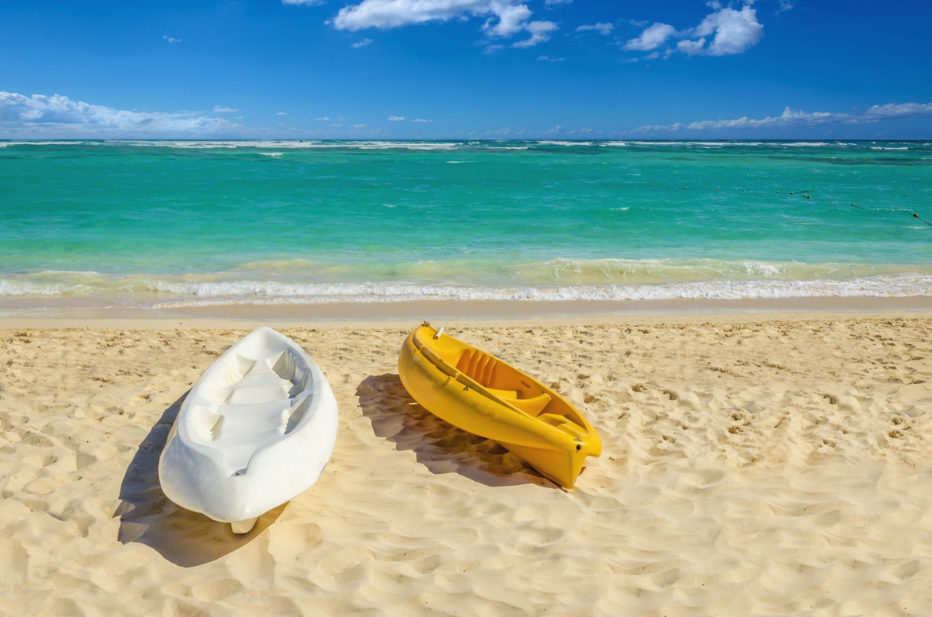 Two empty kayaks on a beach