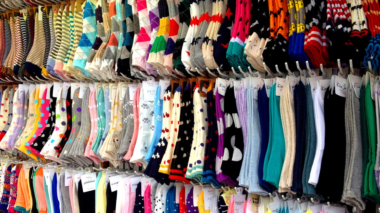 Several racks of socks in a variety of colours and patterns