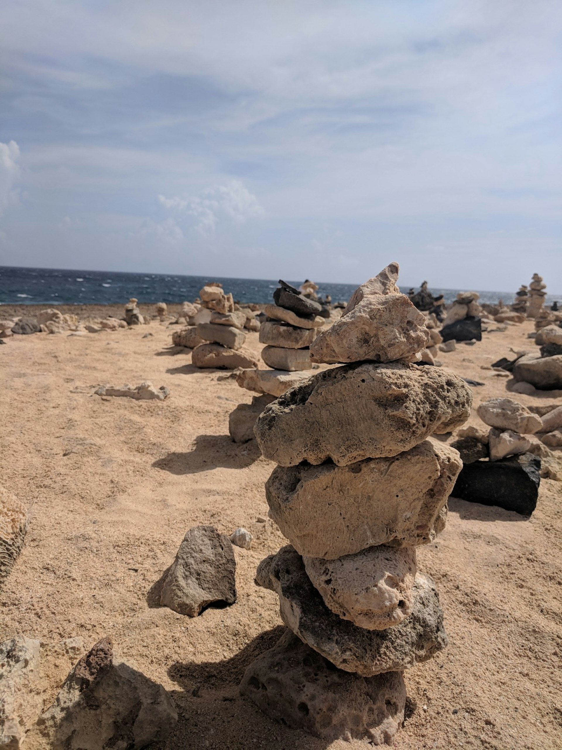 Stacks of rocks cover a beach in Aruba © Alicia Johnson/Lonely Planet 
