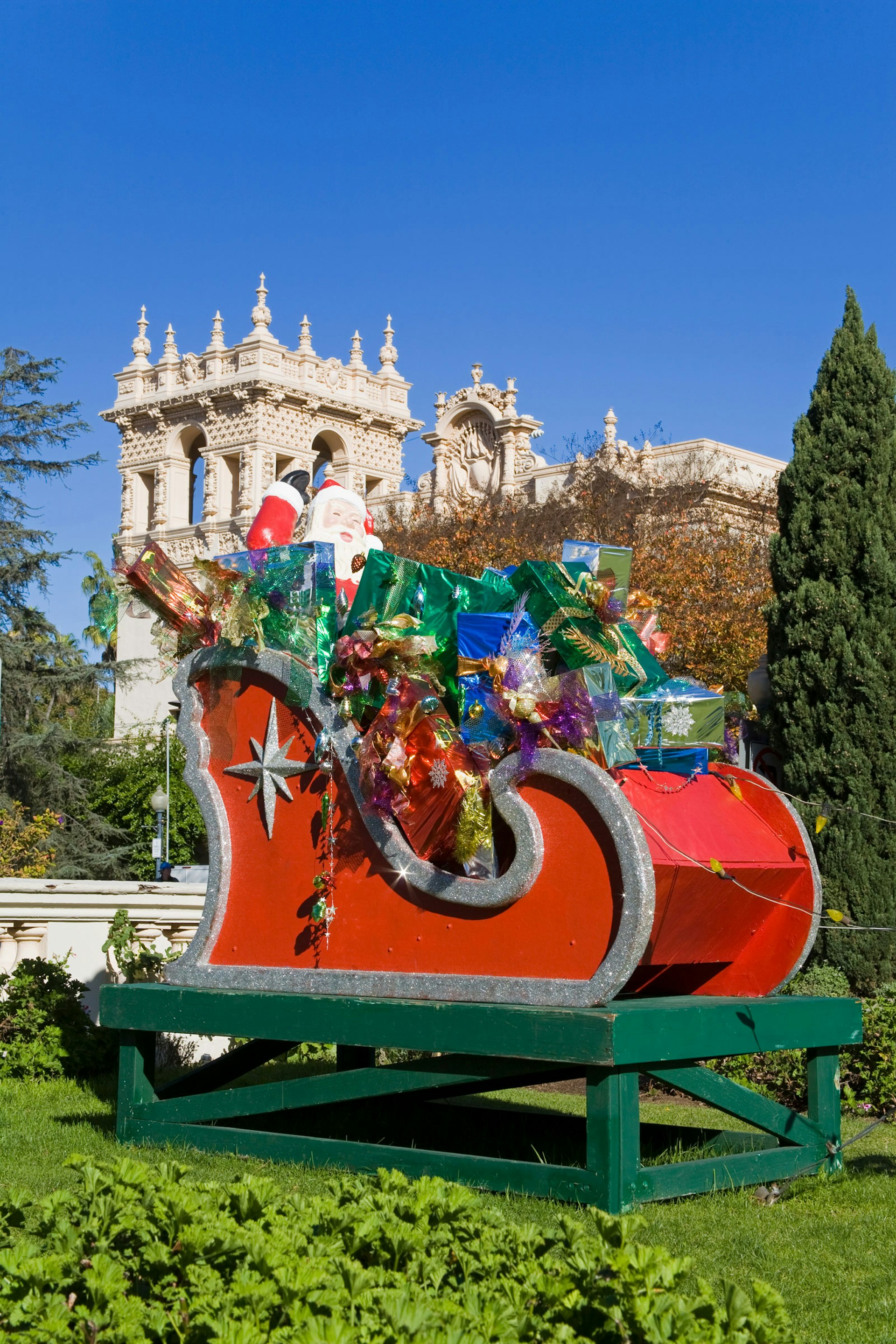 a decorative red sleigh filled with presents and Santa Clause in front of the Museum of Man in Balboa Park San Diego