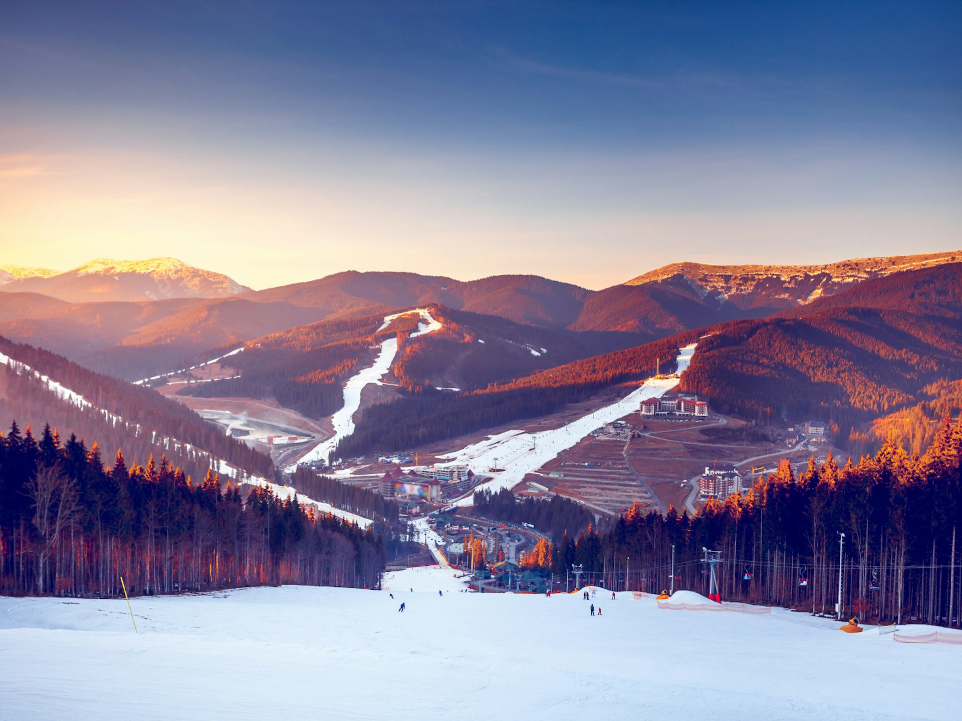 The sun sets over ski tracks and pine-tree forest in Bukovel, Ukraine's biggest ski resort © Volodymyr Goinyk / Shutterstock