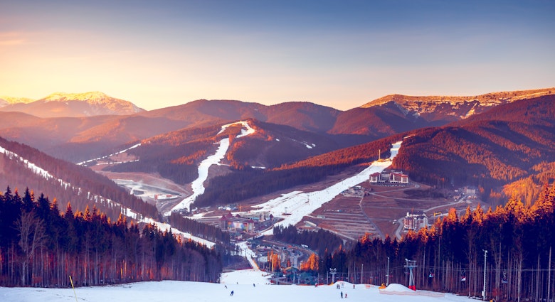 The sun sets over ski tracks and pine-tree forest in Bukovel, Ukraine's biggest ski resort © Volodymyr Goinyk / Shutterstock