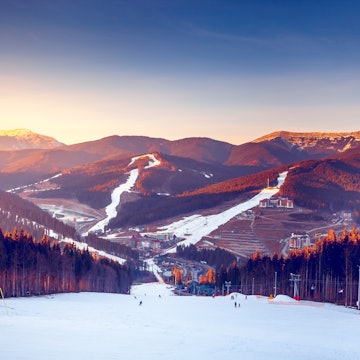 The sun sets over ski tracks and pine-tree forest in Bukovel, Ukraine's biggest ski resort © Volodymyr Goinyk / Shutterstock