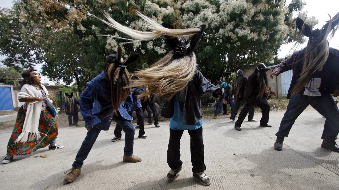 Three men in masks with long beards swing the hair around